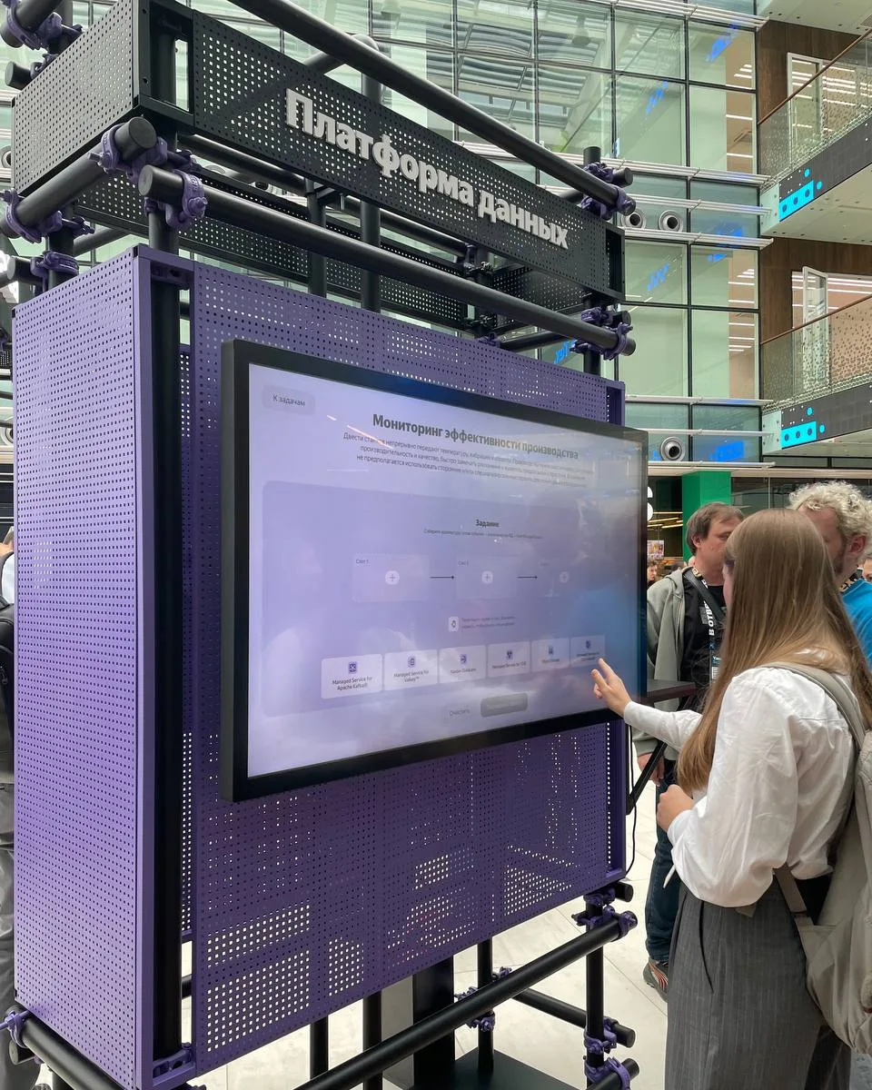The Yandex Cloud data platform booth at Yandex Scale 2026, a visitor playing the game on its touchscreen